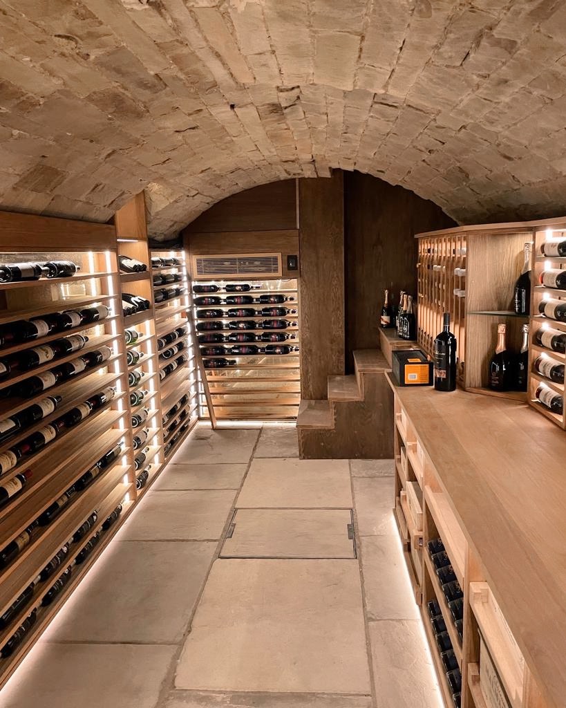 A narrow basement wine cellar with an under the floor arched ceiling
