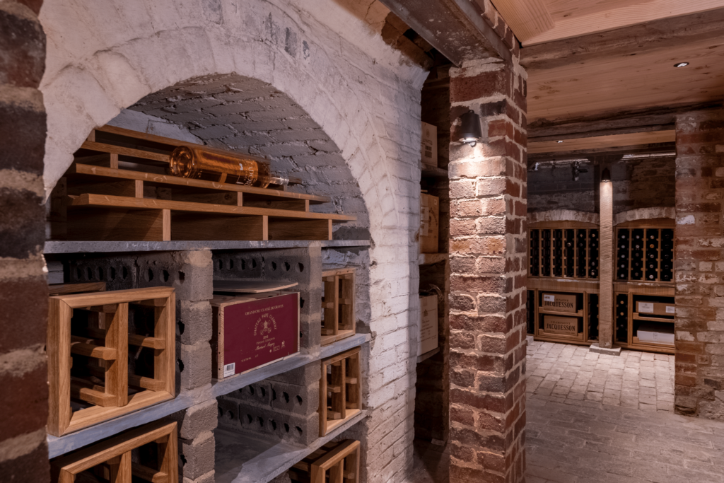 An arched nook within a basement wine cellar with custom wine racks to fit