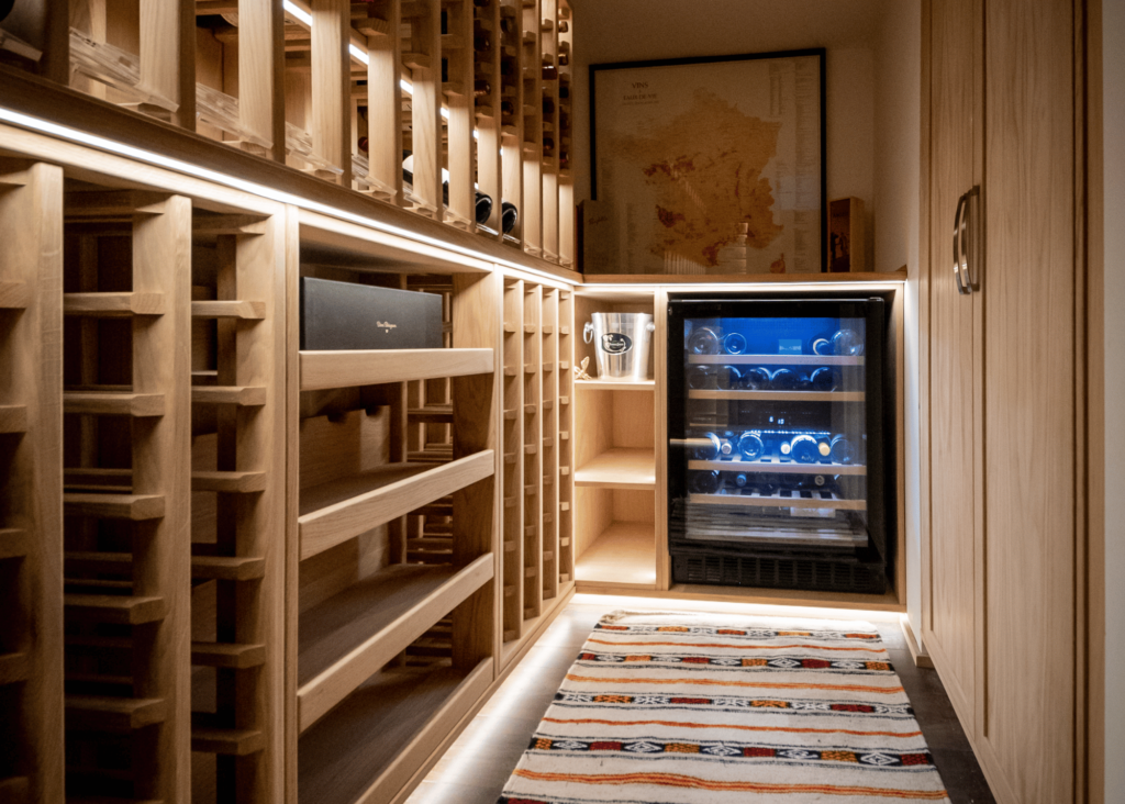 A well-organized wine cellar featuring a built-in wine fridge. The wine fridge is seamlessly integrated into the cellar, providing an ideal storage solution for preserving and showcasing an impressive wine collection. Rows of meticulously arranged wine bottles can be seen on sturdy wine racks, elegantly displayed in a temperature-controlled environment. This wine cellar with a wine fridge offers wine enthusiasts a sophisticated and efficient space to store their prized vintages while adding a touch of luxury to any home or establishment.