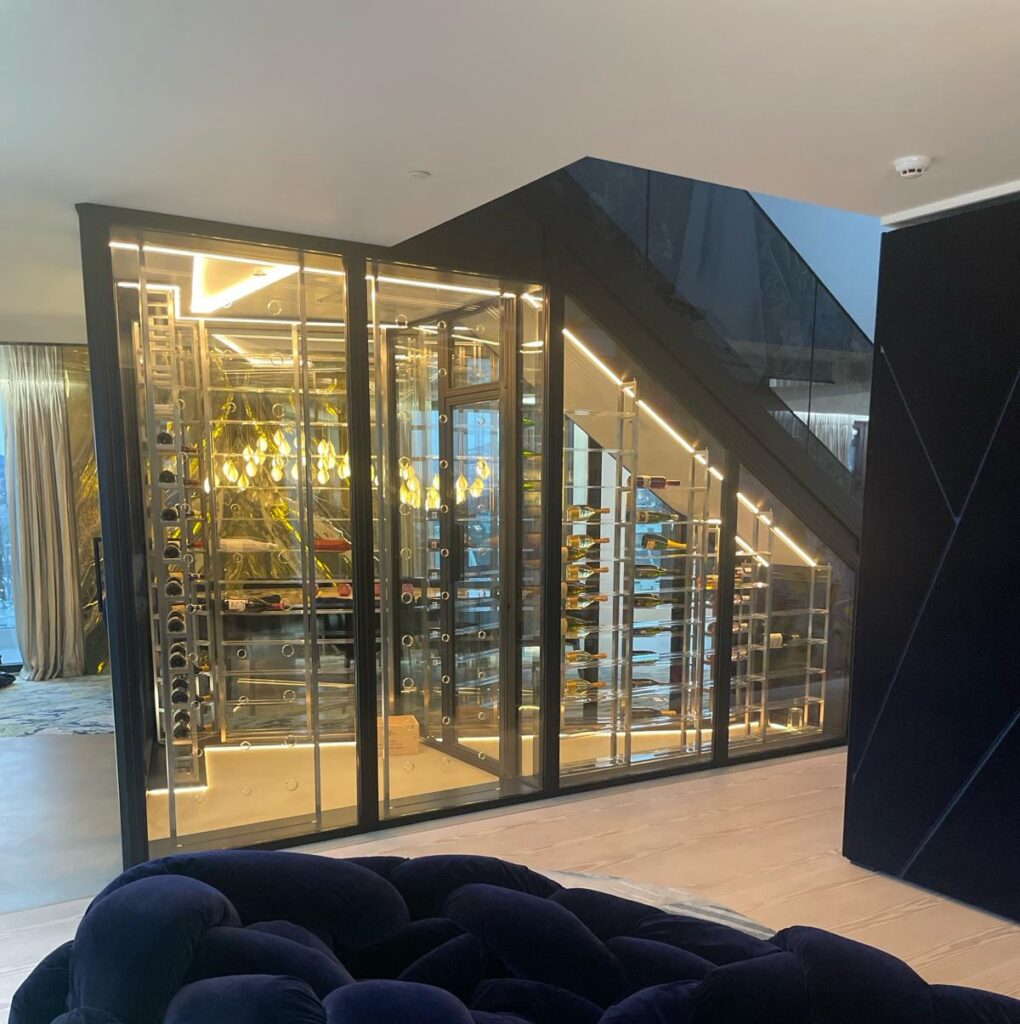 A large under stairs wine wall with bottle neck holders made from acrylic and steel metal wine racks