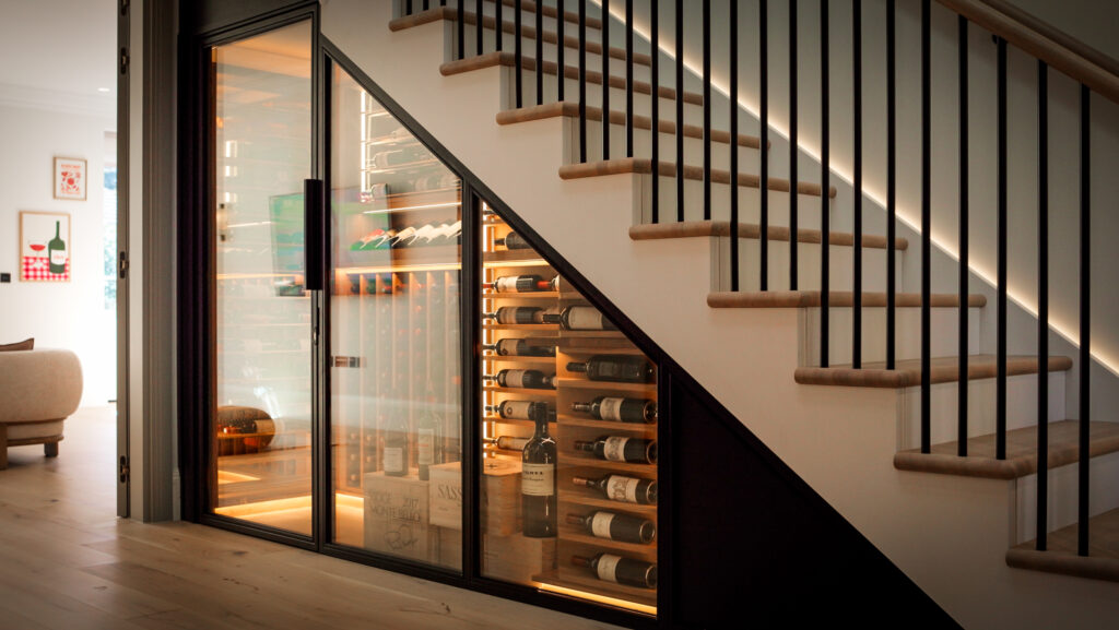 Close-up of bespoke oak wine racking and matt black framework within an under stairs wine cellar
